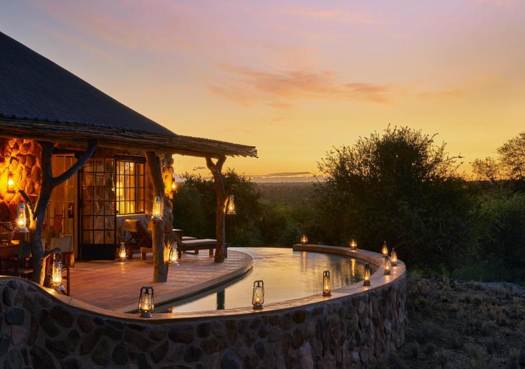 Couché de soleil depuis un Lodge en Afrique du Sud, avec vue sur le lodge, sa piscine et la savane.